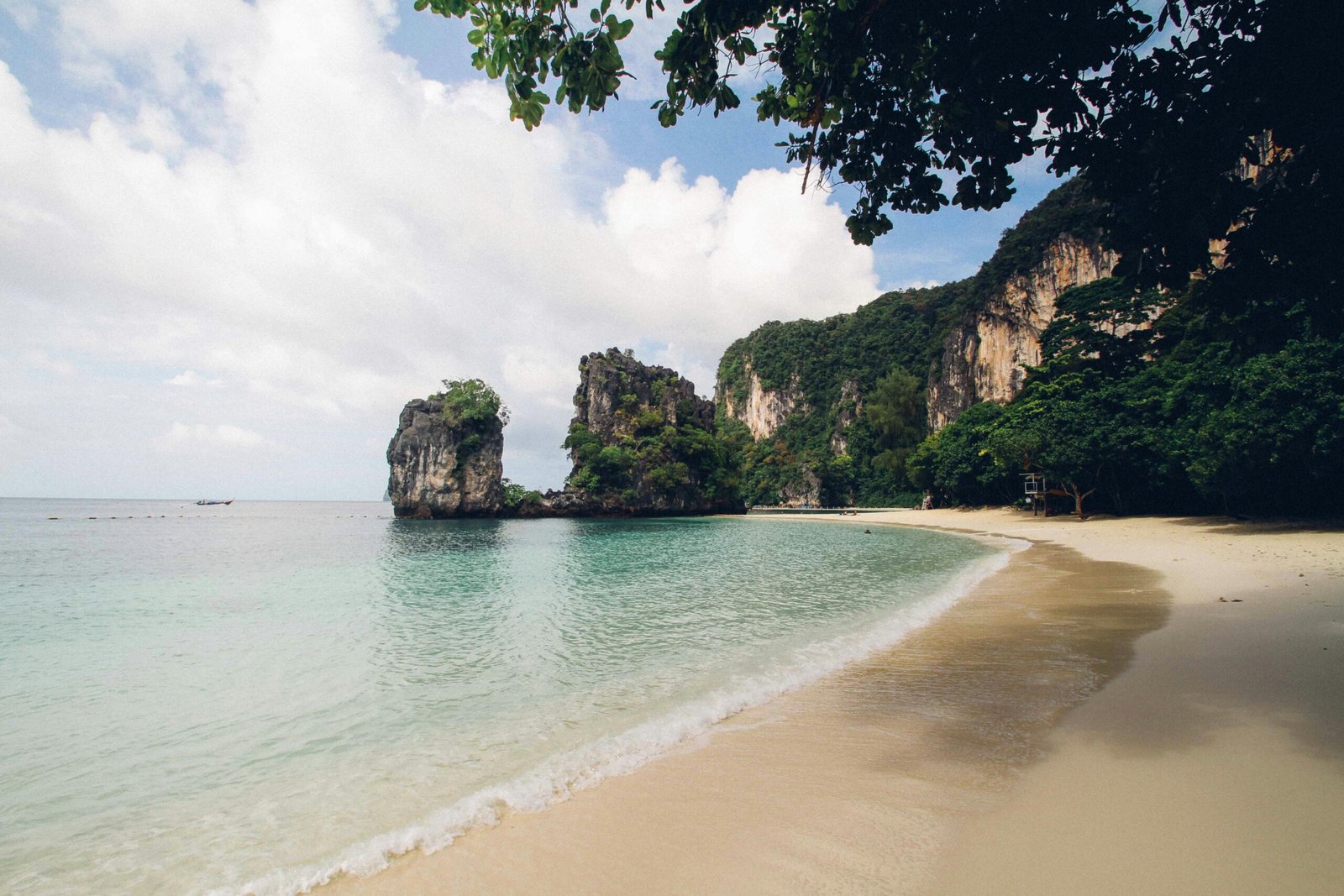 Tranquil beach scene with limestone cliffs in Thailand, perfect for tropical escapes.